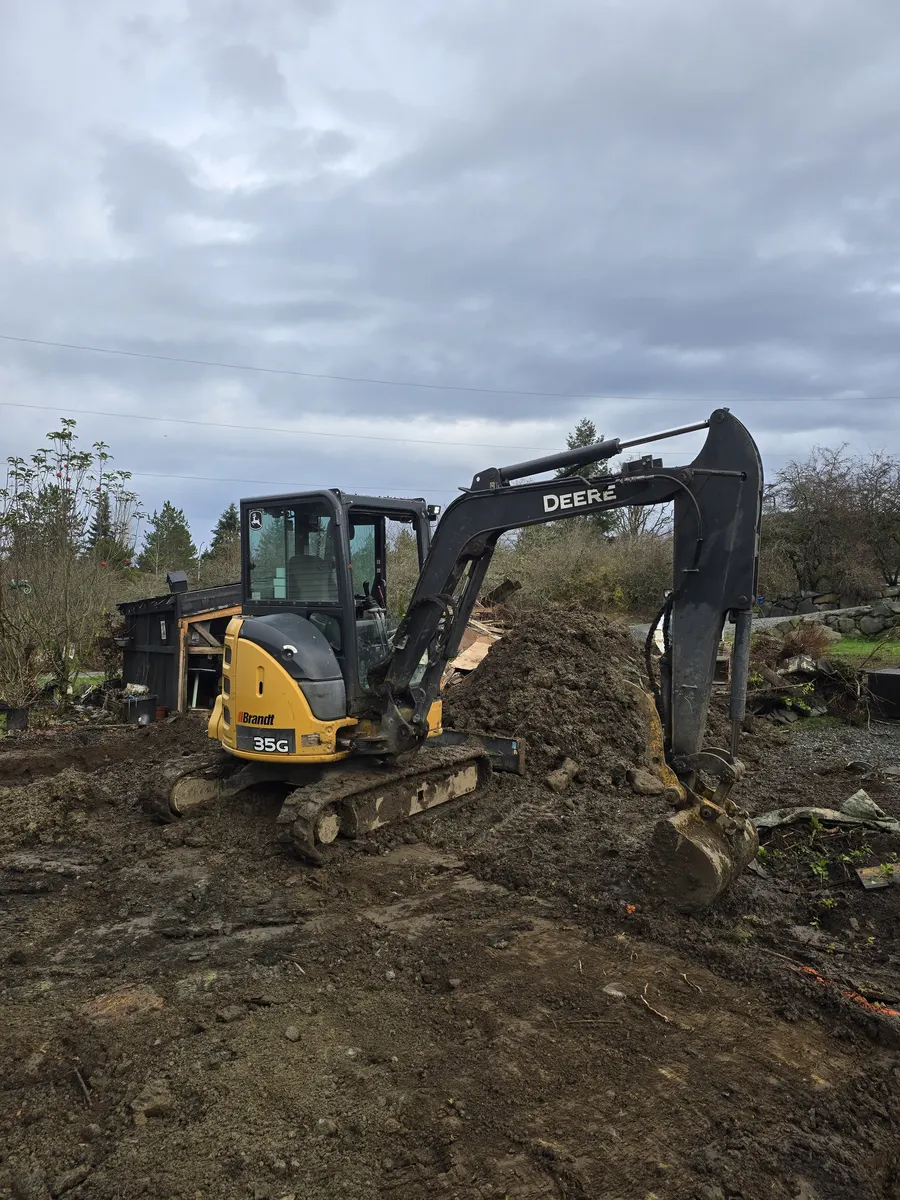 Mini excavator working on residential excavation and land clearing project